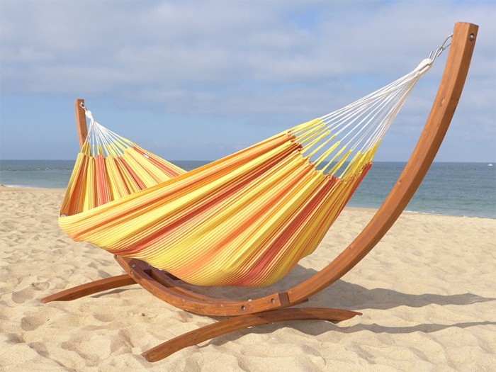 Hamac colombien en coton multicolore jaune et rouge avec support en bois, installé sur la plage