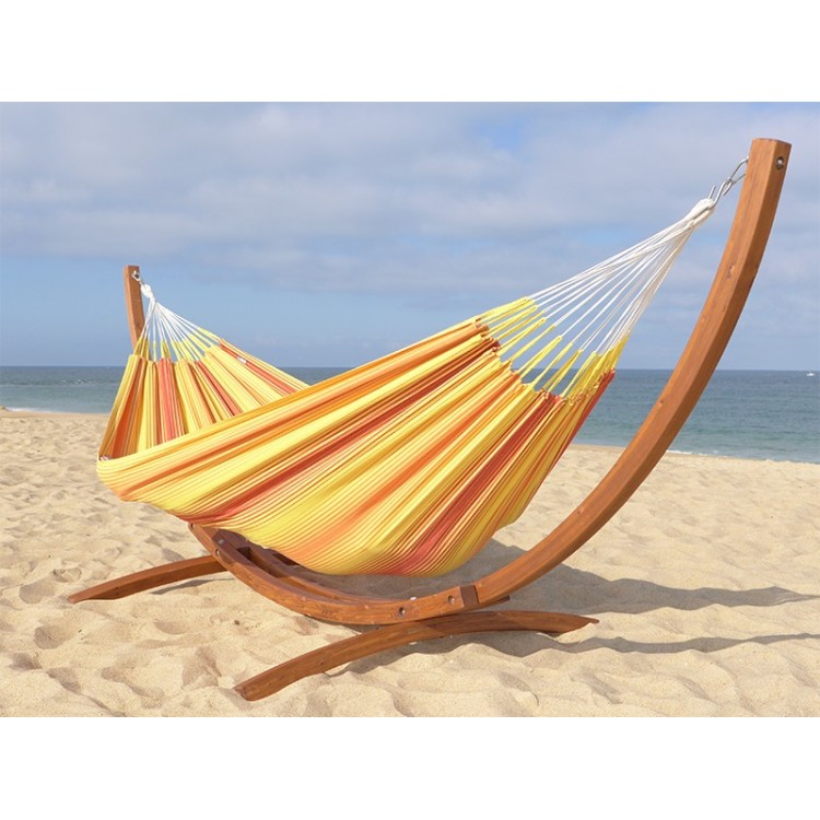 Hamac colombien en coton multicolore jaune et rouge avec support en bois, installé sur la plage