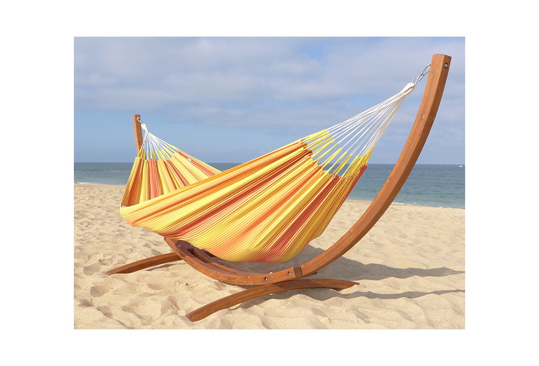 Hamac colombien en coton multicolore jaune et rouge avec support en bois, installé sur la plage