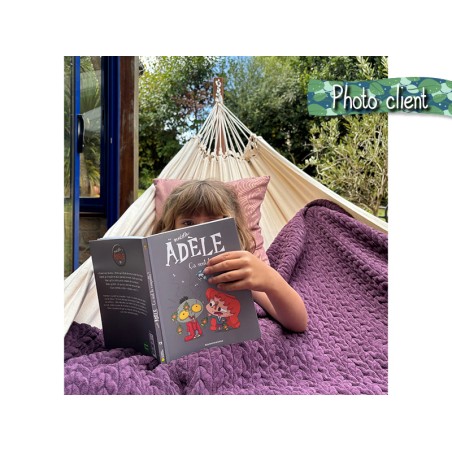 Photo d'une cliente, une petite fille lisant un livre animé, bien au chaud et profitant de son hamac avec support en bois