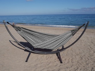 Hamac polygone noir XL allongé avec support métallique, au bord de la mer