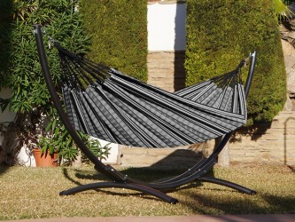 Hamac polygone noir XL avec support métallique, situé dans un jardin ensoleillé