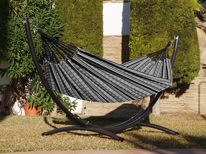 Hamac polygone noir XL avec support métallique, situé dans un jardin ensoleillé