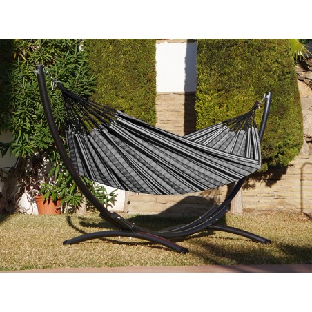 Hamac polygone noir XL avec support métallique, situé dans un jardin ensoleillé