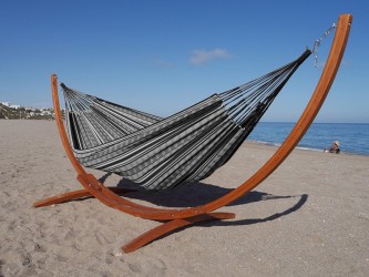 Hamac polygone noir XL avec support en bois, au bord de la mer