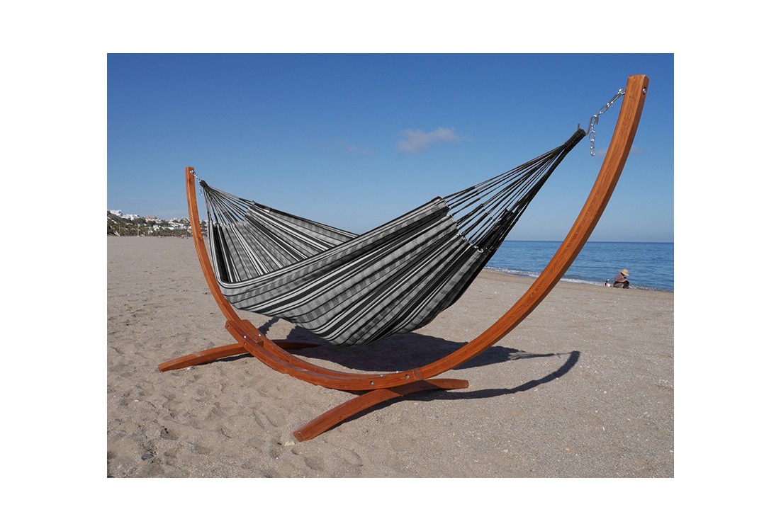Hamac polygone noir XL avec support en bois, au bord de la mer