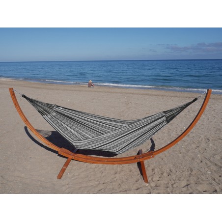 Hamac polygone noir XL allongé avec support en bois, au bord de la mer