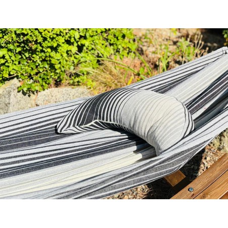 Coussin à rayures grises et blanches sur un hamac de même texture
