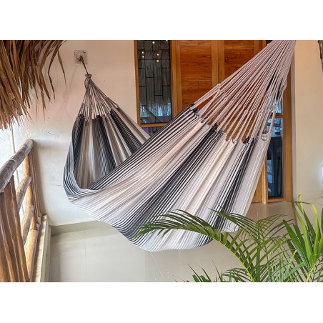 Hamac artisanal colombien gris et blanc suspendu sur une terrasse