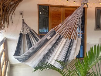 Hamac artisanal colombien gris et blanc suspendu sur une terrasse