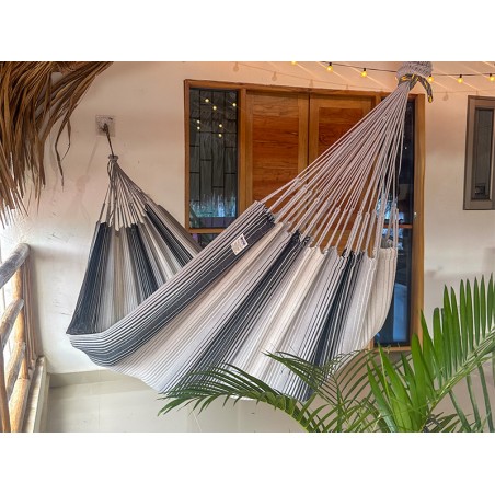 Hamac artisanal colombien gris et blanc suspendu sur une terrasse