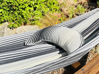 Coussin à rayures grises et blanches sur un hamac de même texture