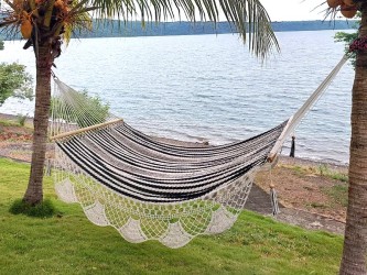 Hamac Nicaragua L à barre, écru et noir installé en extérieur, avec vue panoramique sur le lac