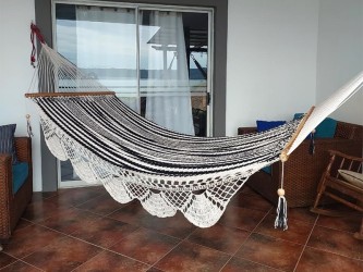 Hamac Nicaragua écru noir installé en intérieur, apportant confort et authenticité artisanale à la décoration