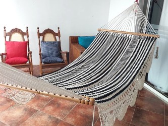 Vue diagonale du hamac artisanal noir et écru, spacieux et confortable, idéal pour la sieste et la lecture