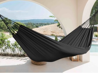 Hamac noir, suspendu sur une terrasse avec vue sur les montagnes