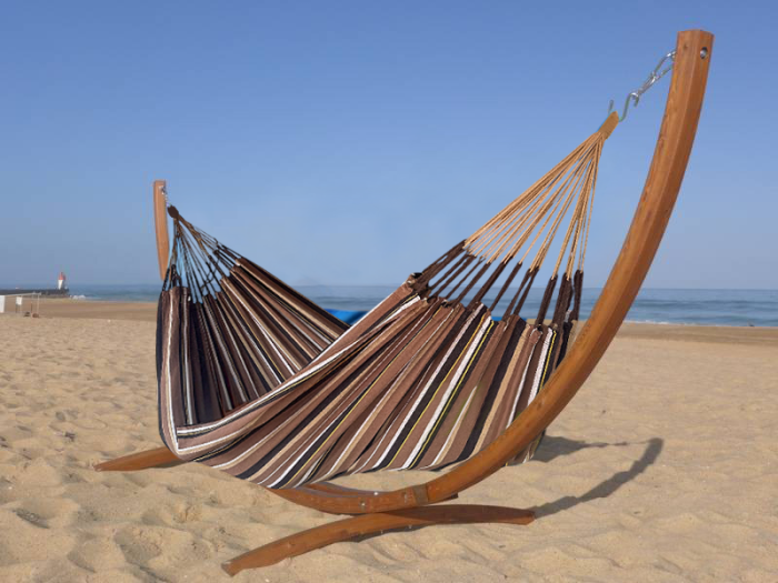 Hamac dans les tons marron en coton recyclé avec support en bois situé en mer