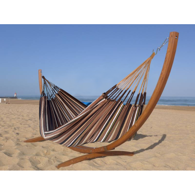Hamac dans les tons marron en coton recyclé avec support en bois situé en mer
