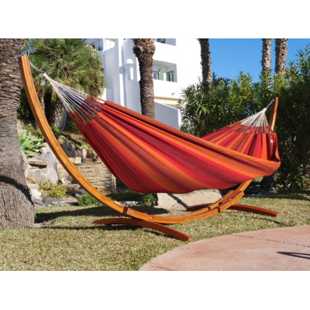 Hamac à rayures rouges avec support en bois dans un jardin