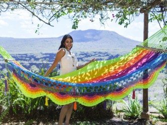 Femme posant et se relaxant dans un hamac aux couleurs vives dans un environnement naturel ensoleillé