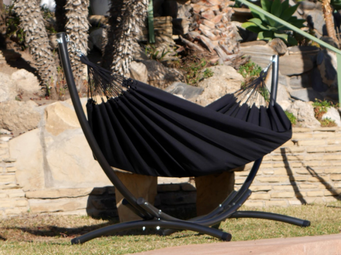 Hamac XL cloud black avec support métallique, situé dans un jardin ensoleillé Hamac XL cloud black avec support métallique, situé dans un jardin ensoleillé