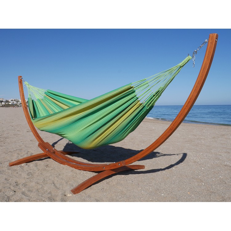 Hamac XL vert à rayures jaunes avec support de hamac en bois au bord de la mer