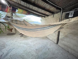 Hamac Moriche à rayures bleues vu de profil sur une terrasse rustique