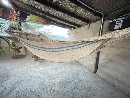 Hamac Moriche à rayures bleues vu de profil sur une terrasse rustique