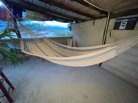 Hamac Moriche à rayures bleues vu de profil sur une terrasse rustique