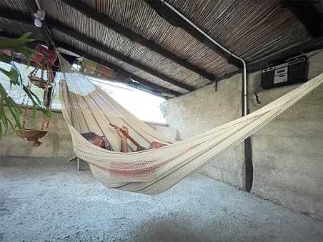 Hamac Moriche à rayures marron vu de profil sur une terrasse rustique