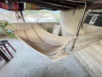 Hamac Moriche à rayures rouges et bleues vu de dessus sur une terrasse rustique