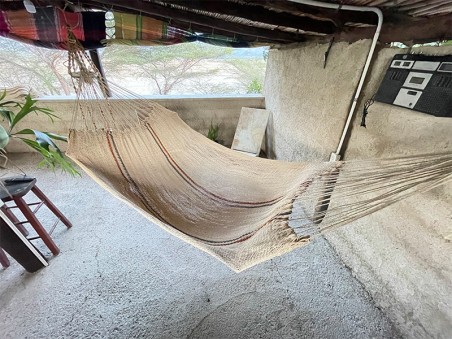 Hamac Moriche à rayures rouges et bleues vu de dessus sur une terrasse rustique
