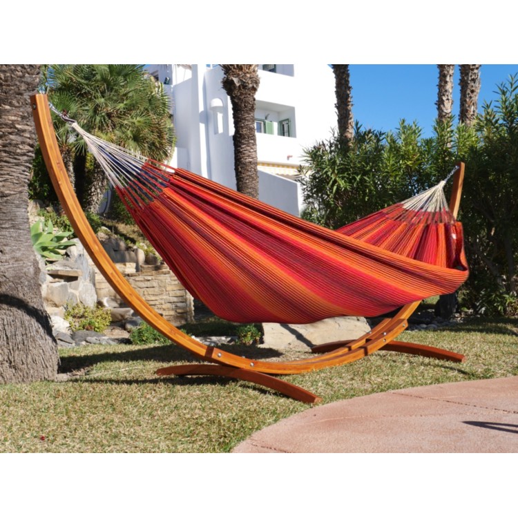 Hamac à rayures rouges avec support en bois dans un jardin