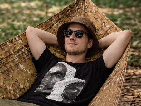 Gros plan d'un homme détendu, les bras ouverts dans un hamac militaire léger 1 place – Toile parachute