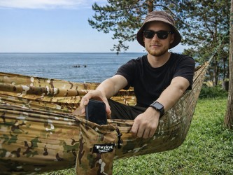 Hamac en tissu souple, homme rangeant son téléphone portable dans la poche du hamac