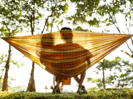 Famille se reposant dans une hamac Explorer L nylon jaune dans une forêt