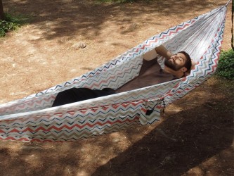 Vue latérale d'une personne se reposant dans un hamac suspendu entre deux arbres