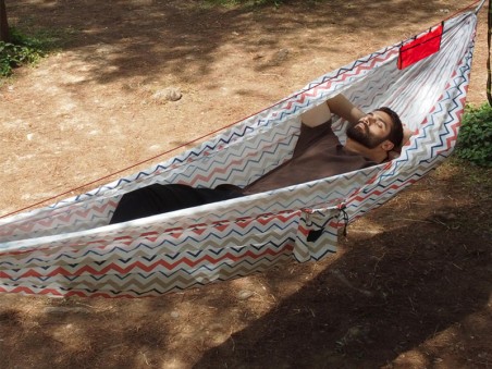 Vue latérale d'une personne se reposant dans un hamac explorer L nylon blanc suspendu entre deux arbres