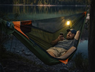 Homme allongé dans un hamac technique avec un tissu résistant et une structure ergonomique