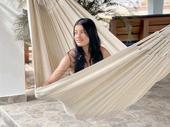 Fille assise dans un hamac CARIBE XXL Écru sur une terrasse