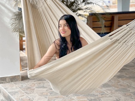 Fille assise dans un hamac CARIBE XXL Écru sur une terrasse