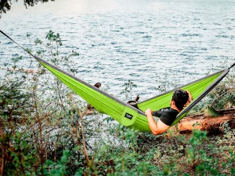 Un homme profitant de la nature, allongé dans un Hamac Outdoor Flex XL Vert et gris