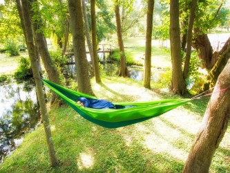 Hamac outdoor flex XL vert installé entre deux arbres en pleine nature, idéal pour la détente en extérieur
