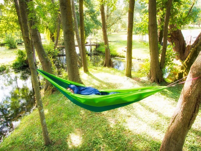 Hamac outdoor flex XL vert installé entre deux arbres en pleine nature, idéal pour la détente en extérieur