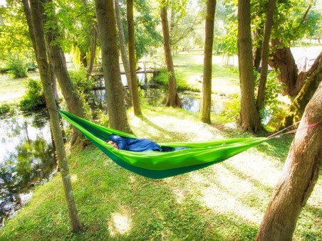 Hamac outdoor flex XL vert installé entre deux arbres en pleine nature, idéal pour la détente en extérieur