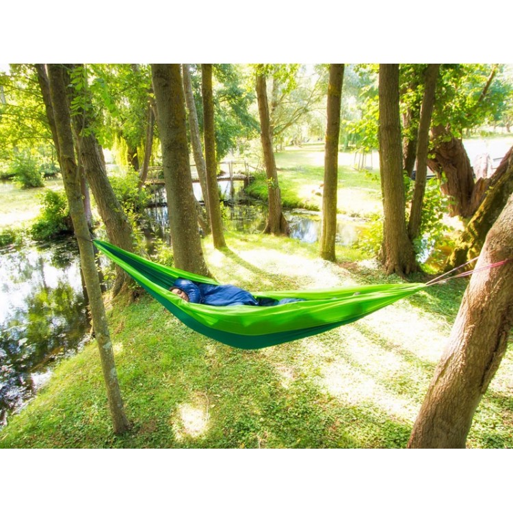 Hamac outdoor flex XL vert installé entre deux arbres en pleine nature, idéal pour la détente en extérieur