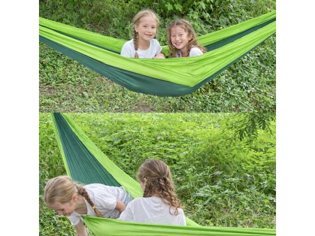 Deux enfants jouent et se reposent dans le hamac, montrant un usage ludique et familial en extérieur
