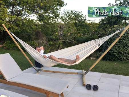 Photo d'un client, allongé dans un Hamac Unicolor recycle XL Ecru dans le jardin de sa maison
