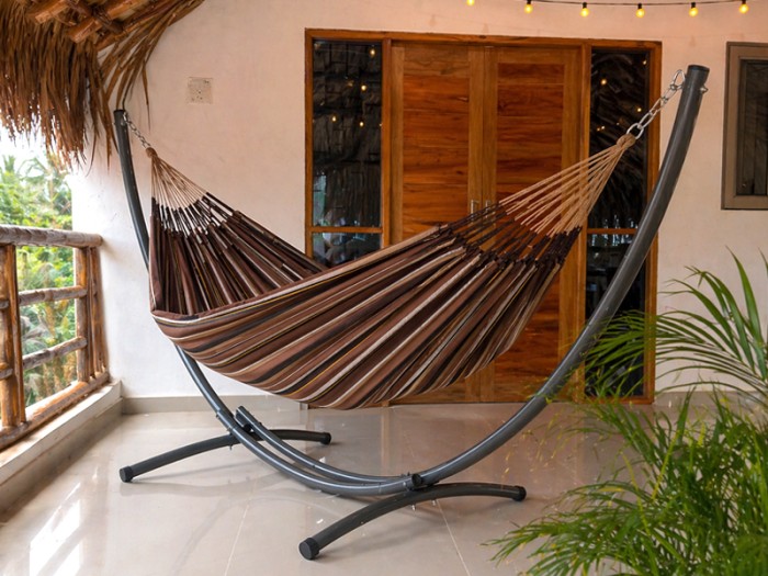 Hamac sur pied Azteka XL Choco Oro sur une terrasse éclairée aux allures tropicales
