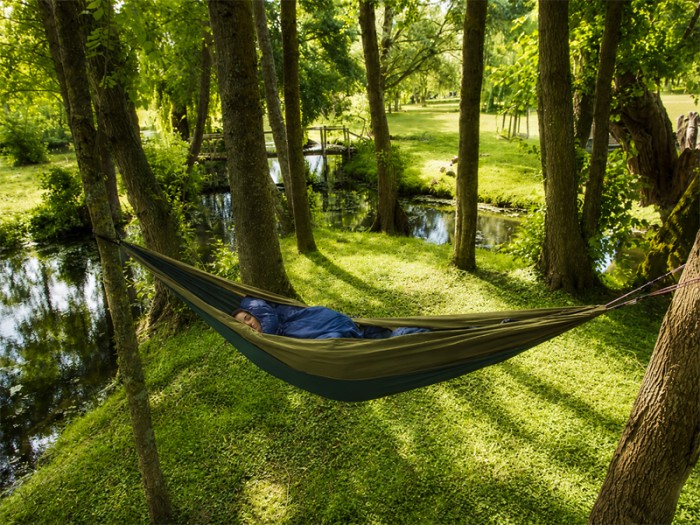 Hamac outdoor flex XL vert installé entre deux arbres en pleine nature, idéal pour la détente en extérieur